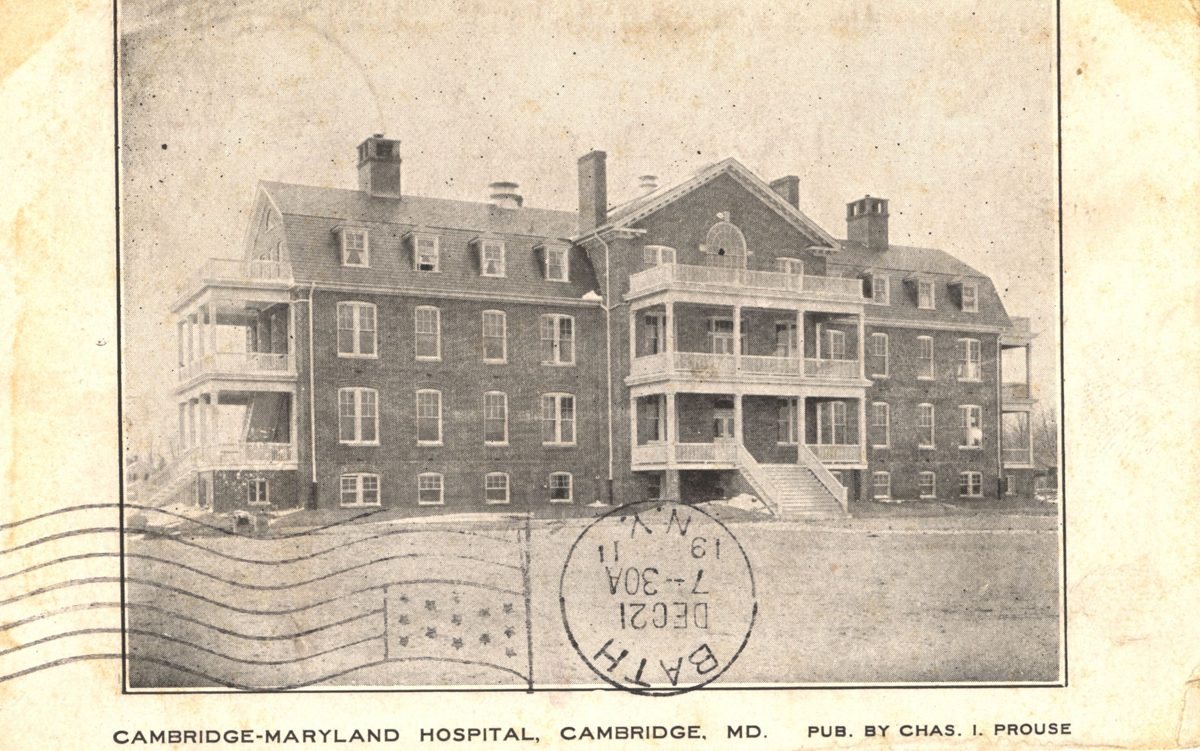 Sepia postcard of a three-story brick hospital with a central two-level porch, labeled Cambridge-Maryland Hospital, Cambridge, MD